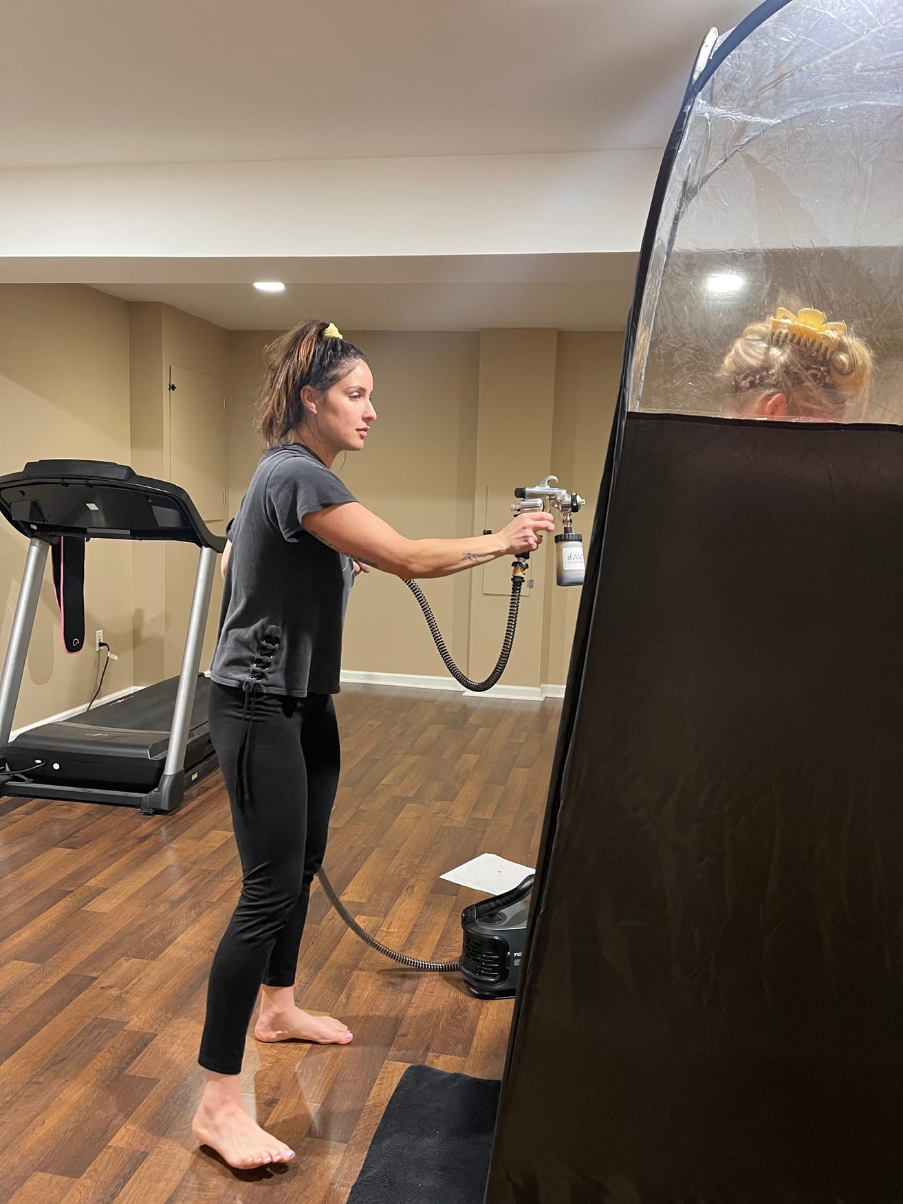 Professional mobile spray tanning session in progress